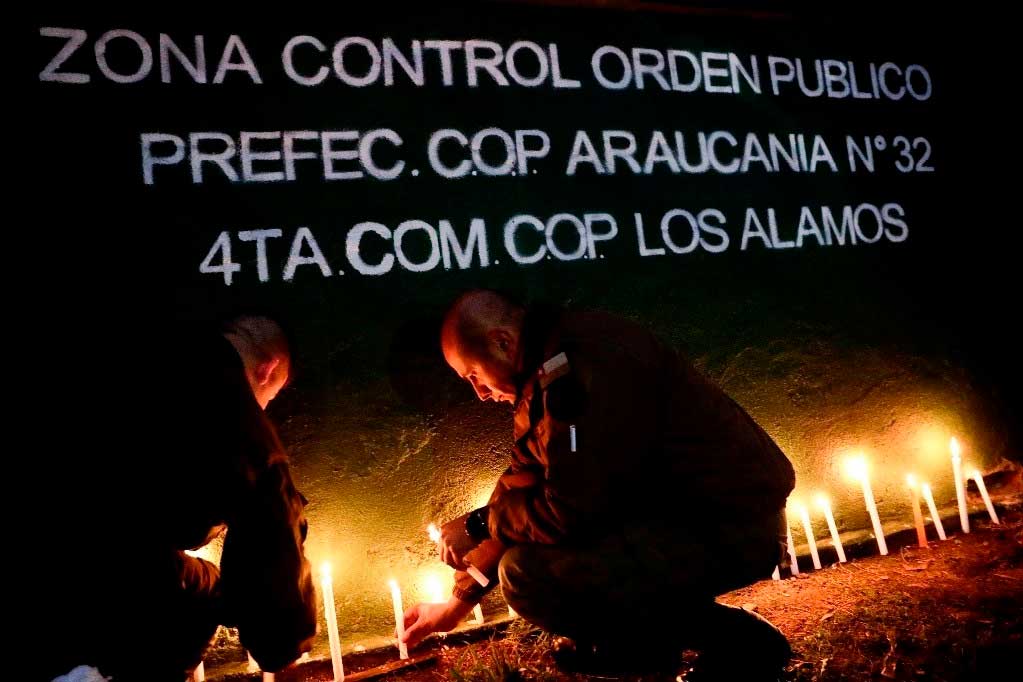 Agentes de policía encienden velas durante una vigilia