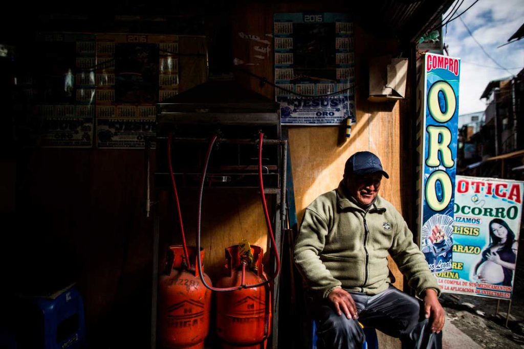 Un hombre sentado afuera de una tienda en Puno, Perú