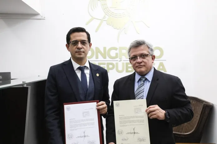 El secretario general de la Presidencia, Juan Guerrero (izquierda) entrega la iniciativa de ley para modificar la Ley Orgánica del Ministerio Público al director legislativo, Luis Eduardo López