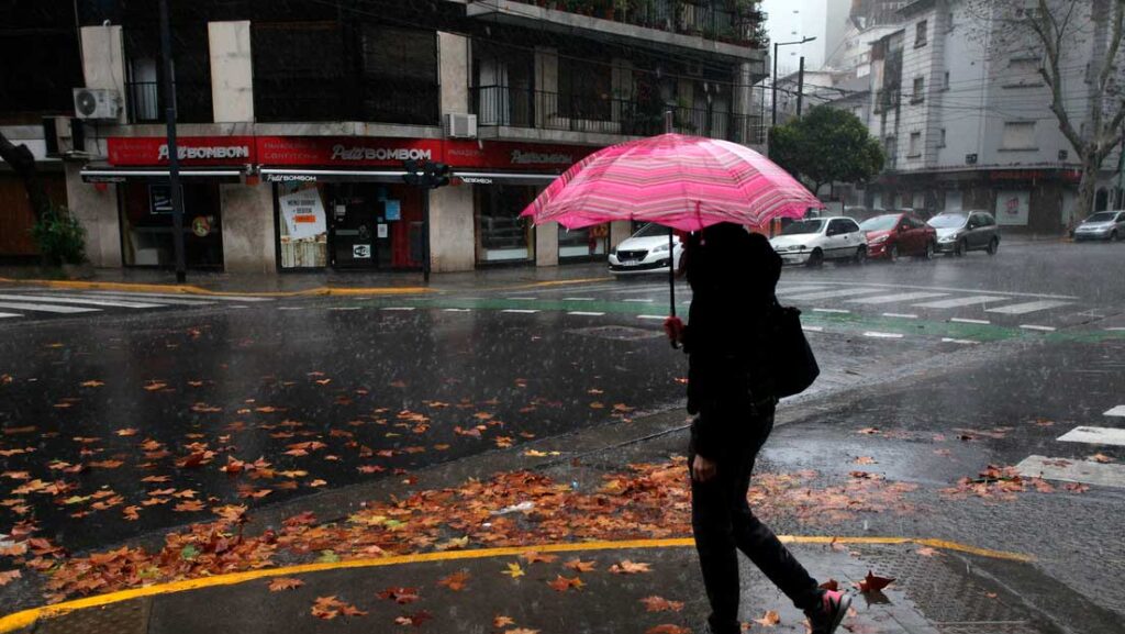 Una mujer camina bajo la lluvia durante un corte de electricidad en Buenos Ares, Argentina, el 16 de junio de 2019