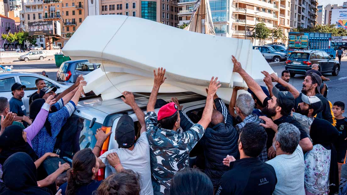 Un grupo de refugiados intentando agarrar un colchón a la entrada de la mezquita de la Plaza de los Mártires de Beirut. 2 de octubre de 2024.