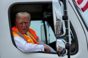 El republicano Donald Trump habla con reporteros desde un camión de basura, al llegar a un mitin en Wisconsin. Foto Ap