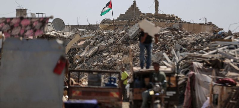 La bandera palestina ondea sobre ruinas en Khan Younis, en el sur de Gaza. Foto: © WFP / Ali Jadallah