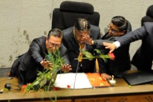 El vicepresidente de Bolivia, David Choquehuanca, se protege de objetos que simpatizantes de Morales arrojaron en la Asamblea Plurinacional. Foto Afp