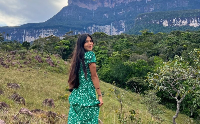 Corina Landáez camina con un vestido diseñado por ella frente al Auyán Tepuy, en el estado Bolívar, Venezuela Instagram @pemon.pachi