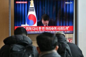 La gente mira una transmisión televisiva en vivo del presidente de Corea del Sur, Yoon Suk Yeol, inclinándose después del final de su discurso, en una estación de tren en Seúl el 7 de diciembre de 2024. Foto Afp