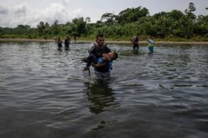 Migrantes cruzan el río Turquesa cerca de la aldea de Bajo Chiquito, el primer control fronterizo de la provincia de Darién en Panamá, el 22 de septiembre de 2023. Foto Afp