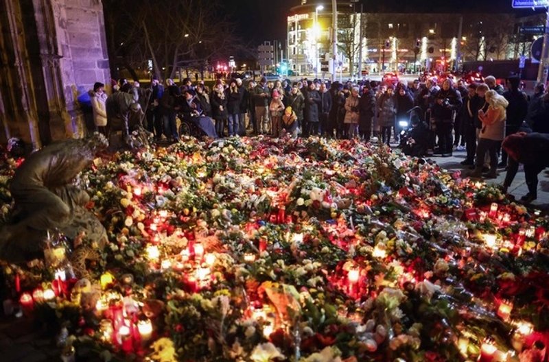 La gente deposita flores en un monumento improvisado cerca del lugar de un ataque con un coche en un mercado navideño en Magdeburgo, este de Alemania, el 21 de diciembre de 2024. Foto Afp