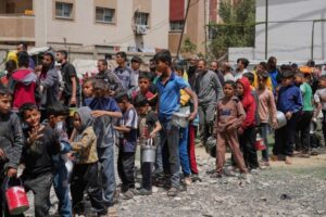 Palestinos esperan alimentos donados en un centro de distribución en Nuseirat, en el centro de la Franja de Gaza, el viernes 11 de abril de 2025. Foto Ap