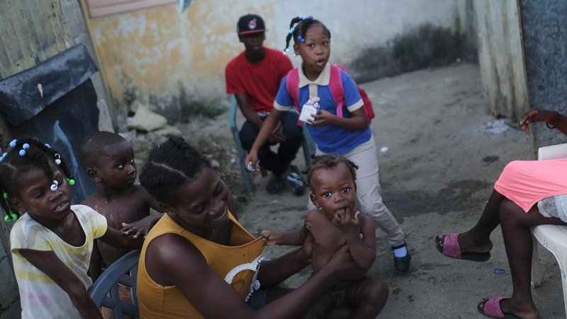 Una mujer sostiene a su hijo en una zona de Santo Domingo, República Dominicana, el 22 de noviembre de 2021. Matias Delacroix / AP