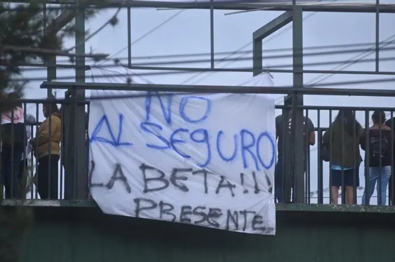 Manifestantes en el bloqueo frente a la colonia La Bethania, zona 7 colocan mantas rechazando el seguro contra terceros obligatorio presentado por la cartera del Interior. Fotos La Hora: Fabricio Alonzo.