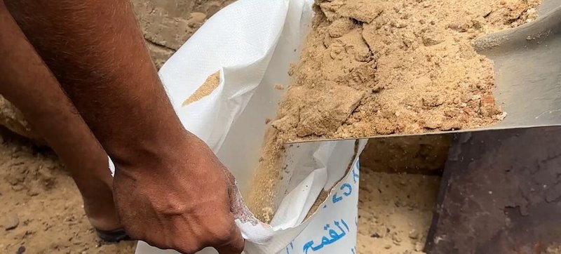 Noticias ONU Las personas desplazadas en Gaza llenan antiguos sacos de harina con arena y los colocan alrededor de sus tiendas de campaña para evitar que entre el agua de lluvia.