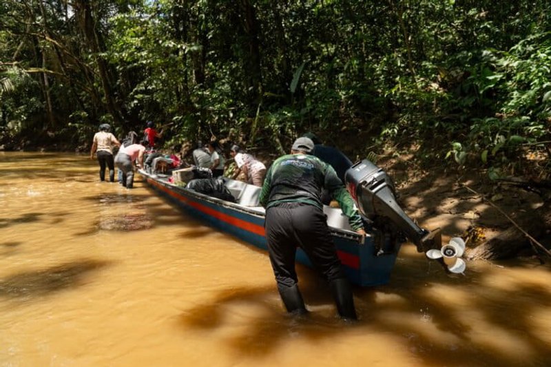 Ante los bajos niveles de la quebrada Jácome, imprevistos para mediados de año, integrantes del resguardo indígena coreguaje de Jácome, en la Amazonia colombiana, empujan la lancha para avanzar en su recorrido. Foto: Terumoto Fukuda.